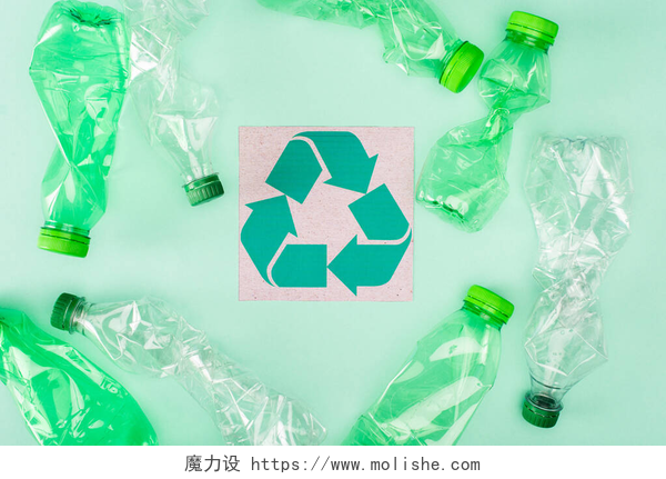 绿色背景上的循环标志和塑料瓶绿色背景、生态概念的折叠式瓶子附近有回收标志的卡片的顶部视图